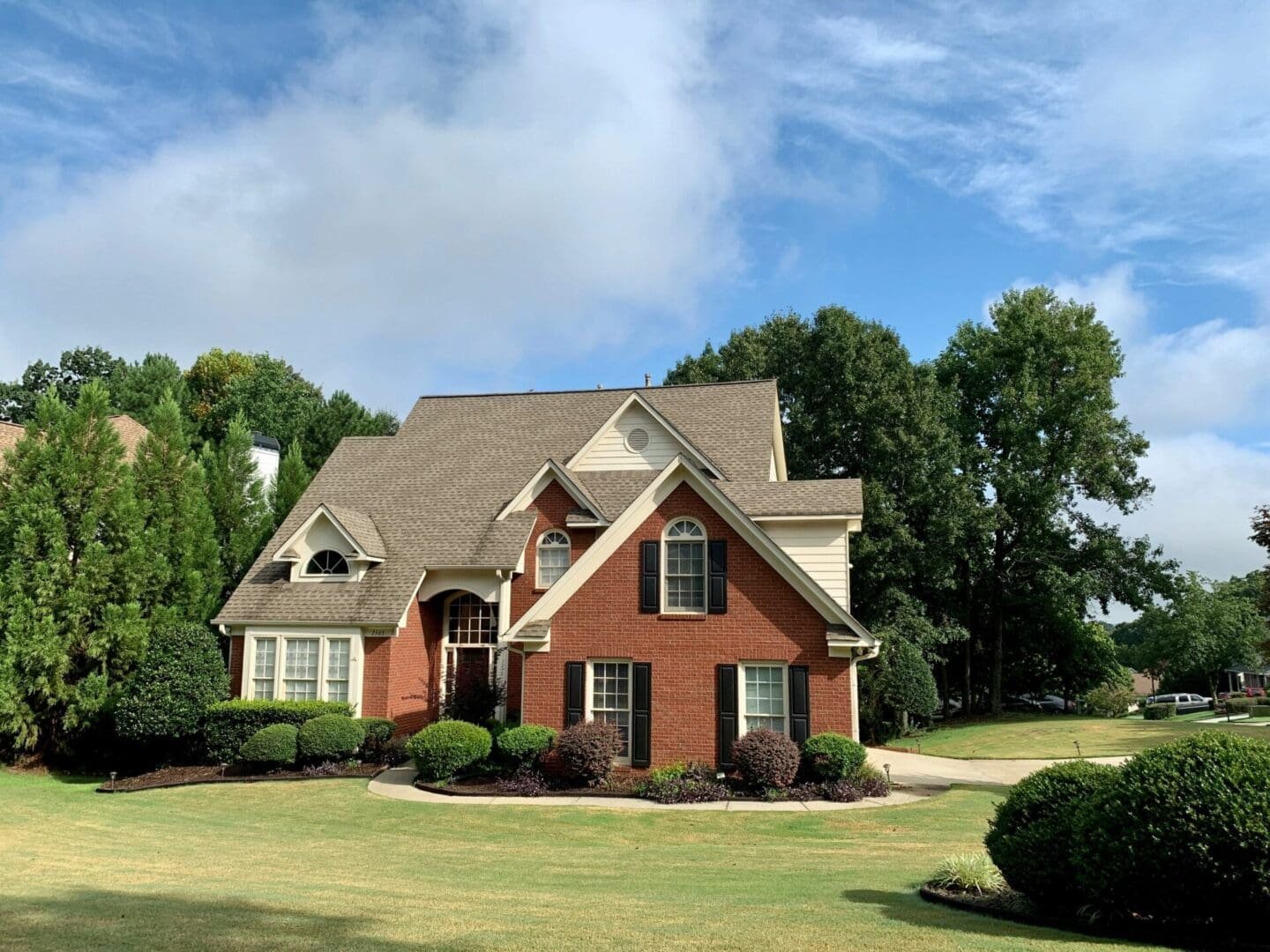 A large brick house with a nice lawn.